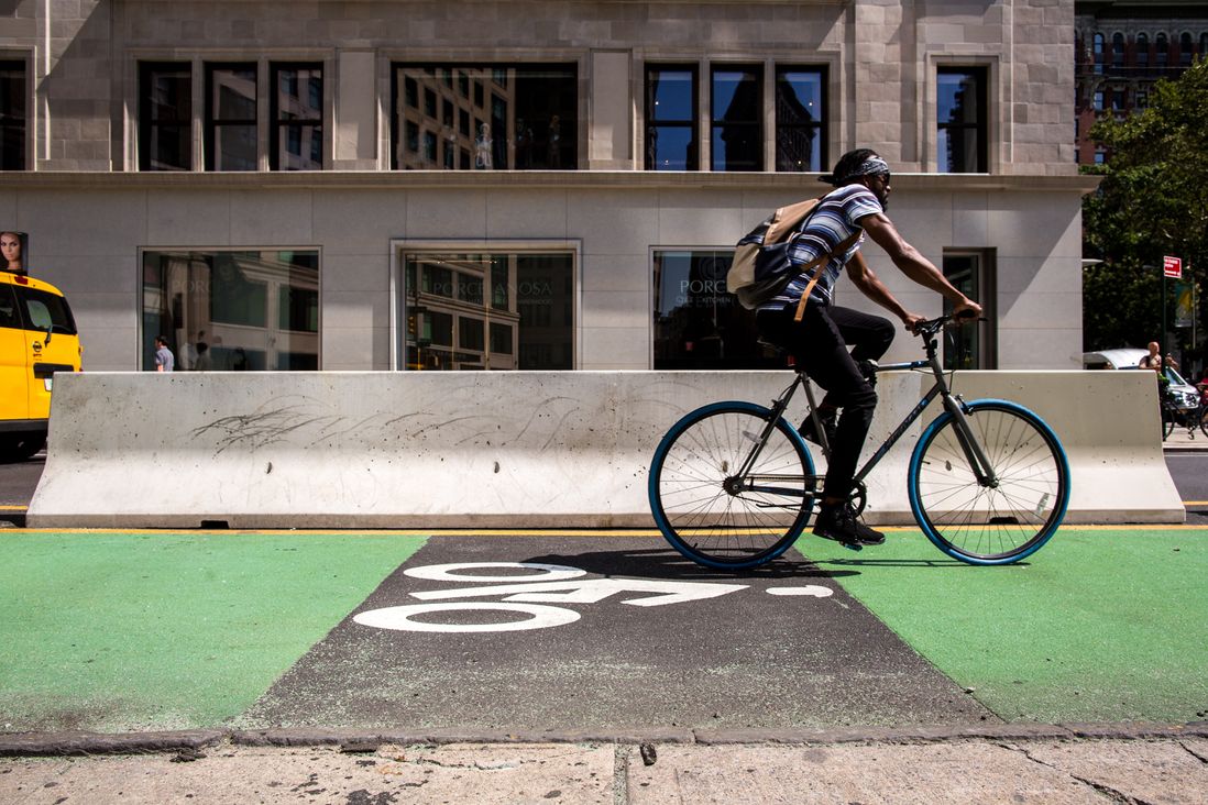 A cyclist uses a new protected bike lane to move east on West 25th Street.</br>